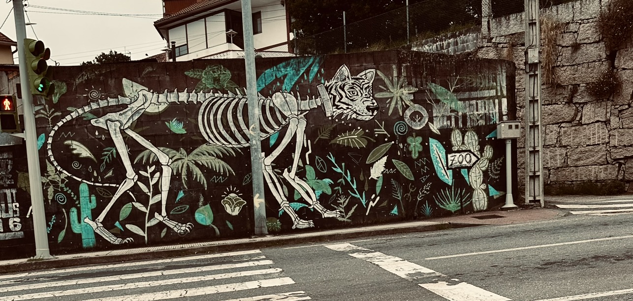 A mural of a skeletal animal amid plants on a street along the Camino de Santiago.